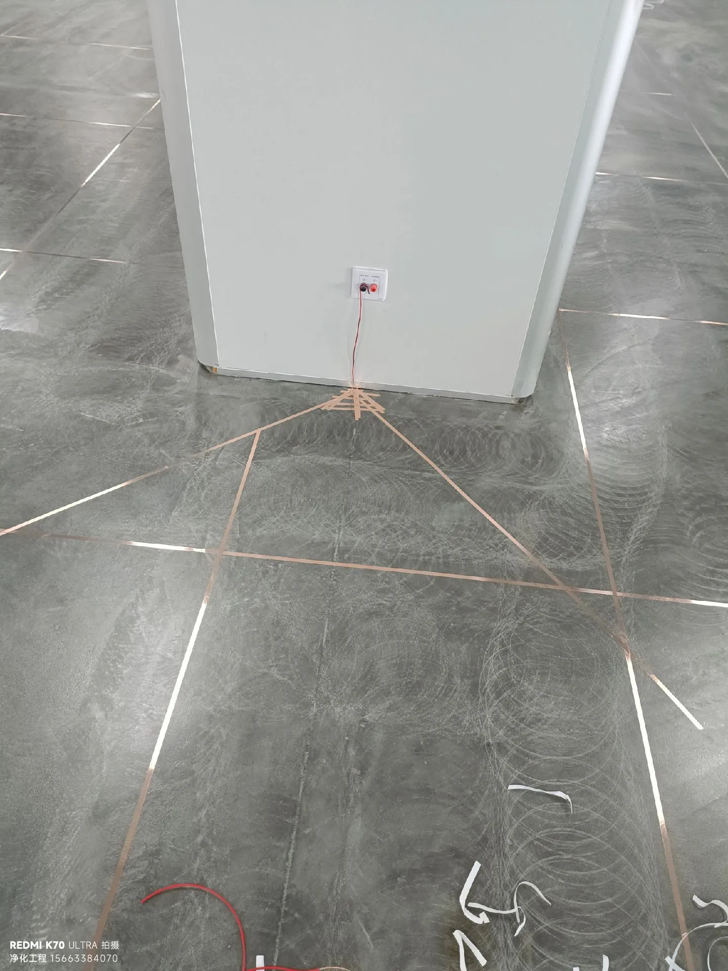 无尘洁净、静电零伤害的现代化车间 一、改造前的"旧时代"：令人头疼的旧车间与连锁危机 环境状况堪忧：脏、乱、险的生产基底 走进改造前的厂房，你首先会感受到的不是什么高科技感，而是一种无处不在的"脏"。 灰尘漫天飞舞 — 员工在生产线上工作，衣服上总是蒙着一层灰。不是因为没人打扫，而是因为地面本身就在不断释放粉尘。原来的混凝土地面早就老化脱皮，每有人员走动，就会产生明显的粉尘。一位车间主任说过："我们的空气质量比室外还差。"  静电隐患无处不在 — 这是最致命的问题。员工在干燥的环境中走动，静电无法及时释放。有时候员工甚至能看到跳起的火花。结果呢？PCB板、芯片等精密电子器件不断被静电击伤。  湿度控制形同虚设 — 夏天潮湿得不行，冬天又干得要命。这种"冰火两重天"的环境对电子制造简直是灾难。焊点容易出现虚焊，芯片容易受潮，不良品率居高不下。  噪音和空气质量差 — 没有专业的空调系统，夏天靠开窗，冬天靠生煤炉。生产过程中产生的各种污染物（焊烟、助焊剂挥发物等）直接排放到车间里，员工的职业病发生率相当高。  数据说真话：触目惊心的环境与生产指标 改造前的检测数据和生产数据，直接暴露了车间的核心问题： 环境指标 检测值 评价 悬浮粒子浓度 (μm) 280,000 个/m³ ❌ 严重超标（标准≤3,500） 相对湿度 35%-75% ❌ 波动剧烈（标准45%-55%） 表面静电电阻 >10¹² Ω ❌ 无法泄放（标准10⁶-10⁹ Ω） 空气离子浓度 5,000个/cm³ ❌ 严重不足（标准≥20,000个/cm³） 温度 16°-32° ❌ 波动过大（标准20°-24°） 生产端的"连锁反应"：不良率、成本与口碑的全面崩塌 恶劣环境带来的不是单一问题，而是全链条的生产危机： 产品不良率飙升：电路板焊接不良率8-12%（业界标准1-2%以内），芯片静电击伤率3-5%，整体一次合格率仅75%左右；  返工成本居高不下：每月返工件数2000+件，年返工成本约180万，部分产品直接报废；  交期压力大：产品出货延期率30%-40%，客户投诉率24%（行业优秀水平<5%），订单跳单、合同解除时有发生；  人员流失严重：年离职率高达45%，技术员工流动性大，招聘与培训成本直线上升。  二、改造决策与方案设计：从"要干净"到"系统性升级" 老板的"痛定思痛"时刻：环境改造是生存必需 这家企业的老板终于坐不住了。2024年底的一次董事会上，摆在桌面的数据再也无法忽视："我们不是在做电子产品，我们是在做垃圾处理。" 一位资深客户更是直言不讳地说出了合作终止的理由："你们的产品质量太不稳定了，我们承受不起。" 这句话就像一个"信号弹"，终于点醒了所有人：环境改造已经不是选项，而是必须。 调研与规划阶段：两周深度诊断，找准核心问题 老板提出的需求看似简单："把车间搞得干净一点。"但我们知道，这远不止"干净"这么简单。工程师团队开展了为期两周的深度调研： 调研内容包括：现场环境检测（粒子浓度、静电、湿度、温度等）、生产工艺分析（不良高发环节）、设备配置评估（现有HVAC系统、供电系统等）、成本-效益分析（改造投入vs预期收益）。 关键发现：这不是简单的地面问题，而是整个车间环境系统的全面缺失；需分区设计分级洁净度；防静电是核心生死线；必须配套智能化管控，实现实时监测与自动调节。 三、改造方案详解："三位一体智能洁净无尘系统"落地 总体思路：三大核心系统，构建环境保障体系 我们给出的改造方案核心为"三位一体智能洁净无尘系统"，通过三大模块协同，从源头解决环境问题： 防静电地坪系统 — 从源头消除静电隐患；  洁净无尘空调系统 — 营造恒温恒湿的无尘环境；  智能环境监测系统 — 实时监测和自动调节，保障环境稳定。  防静电地坪系统：不止于"铺砖"，构建全域泄放网络 很多人误以为"铺防静电砖就行"，但电子厂需要的是整体、无缝、智能的防静电系统，而非局部解决方案。我们的方案分四步落地： 基层处理（第一步）：铲除原有地面约50mm，用混凝土垫层找平（平整度≤2mm/2m），铺设防潮膜（避免后期返潮影响性能）；  导静电层（第二步）：铺设2mm厚导电网格（间距1m×1m），形成完整泄放网络，所有网格点连接到接地桩；  面层工艺（第三步）：采用3mm防静电环氧树脂地坪+2mm防静电聚氨酯面层，兼顾防静电性能、耐磨性与易清洁性；  接地系统（关键）：安装专业多点静电接地柱，每100m²至少1个接地点，确保接地电阻<1Ω（硬指标）。  防静电性能指标验证： 指标项目 要求标准 实现值 评价 表面电阻率 10⁶-10⁹ Ω/sq 3.5×10⁸ Ω/sq ✅ 合格 接地电阻 < 1 Ω 0.8 Ω ✅ 优秀 衰减时间 (0.1µC) < 2s 1.2s ✅ 优秀 滑动摩擦系数 0.4-0.6 0.52 ✅ 安全 耐磨性 PEI ≥ III PEI V ✅ 优秀 耐化学腐蚀 耐焊烟、助焊剂 通过 ✅ 合格 铺设2mm厚导电网格（间距1m×1m），形成完整泄放网络，所有网格点连接到接地桩  智能洁净无尘空调系统：硬核配置，分级营造洁净环境 洁净空调绝非"制冷+制热"这么简单，核心是实现高效过滤、恒温恒湿、合理气流组织与压差控制，我们采用"分级洁净"策略，平衡需求与成本： 分区设计理念 区域划分 洁净等级 用途 粒子浓度标准 A区（核心区） ISO Class 7 PCB焊接、芯片安装 ≤3,500 个/m³ (≥0.5µm) B区（一般区） ISO Class 8 物料准备、检测 ≤35,000 个/m³ C区（缓冲区） ISO Class 9 办公、休息区 ≤350,000 个/m³ 具体核心配置 进气系统：三级过滤（G4初效→F7中效→H13高效HEPA），送风量确保A区每小时换气≥20次、B区12次、C区8次；  加湿/除湿模块：干雾加湿器（避免二次污染）+转轮除湿机，精准控制湿度±5% RH；  温度控制：PLC自动控制系统，精度±1°C，配置冗余冷热源保障故障时环境稳定；  气流组织：顶部送风、底部回风，送风口均匀分布形成层流，保障工作台面空气洁净；  排气系统：H13级高效排气过滤器，兼顾环保与防污染倒灌。  运行数据对比：环境指标全面达标 指标 改造前 改造后 改善幅度 悬浮粒子浓度 280,000个/m³ 2,800个/m³ ↓ 99% 相对湿度 35%-75% 45%-55% ↓ 波动89% 温度波动 ±8°C ±1°C ↓ 波动88% 空气洁净度 N/A ISO 7-8级 ↑ 从无到有 换气次数 2-3次/小时 12-20次/小时 ↑ 600% 南京某电子厂改造前后对比：旧车间vs智能无尘+防静电地坪  智能环境监测系统：防灾减灾，让环境"可感知、可调节"